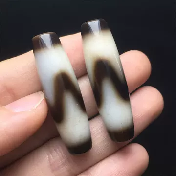 虎牙天珠 双虎牙天珠，也叫四线虎牙。 尺寸50*12.3 虎牙一直在天珠图腾为